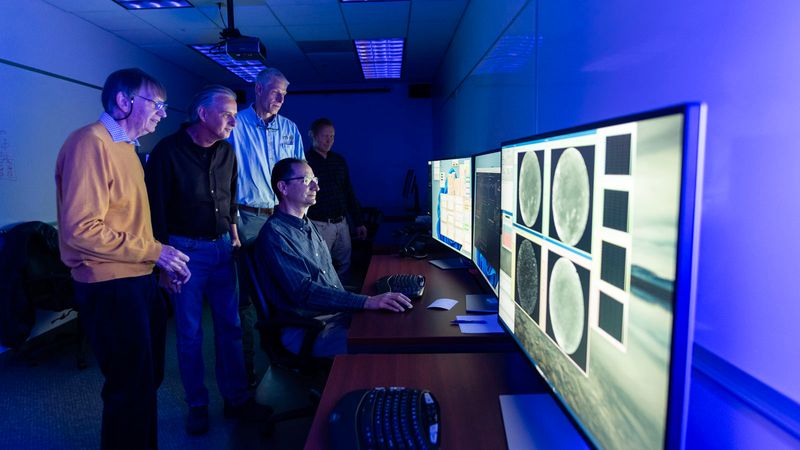 AWE Emeritus Principal Investigator Michael Taylor and Principal Investigator Ludger Scherliess of USU’s College of Science, along with Project Manager Burt Lamborn, Ground Systems & Mission Operations Manager Pedro Sevilla, and Systems Engineer Harri Latvakoski from SDL, observe some the first live images from the AWE instrument being transmitted from the ISS to AWE’s Mission Operations Center at SDL.
